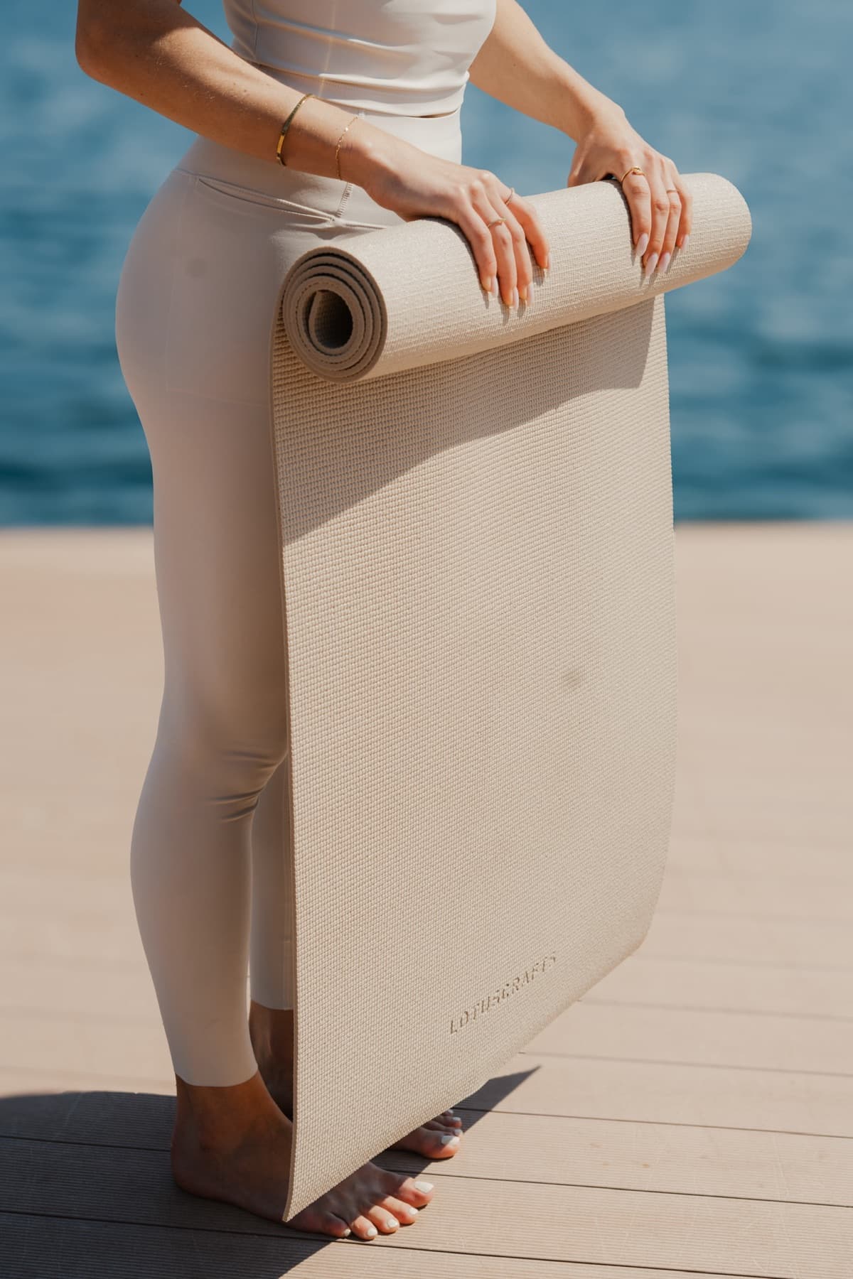 Frau mit Yogamatte am Steg in Velden am Wörthersee